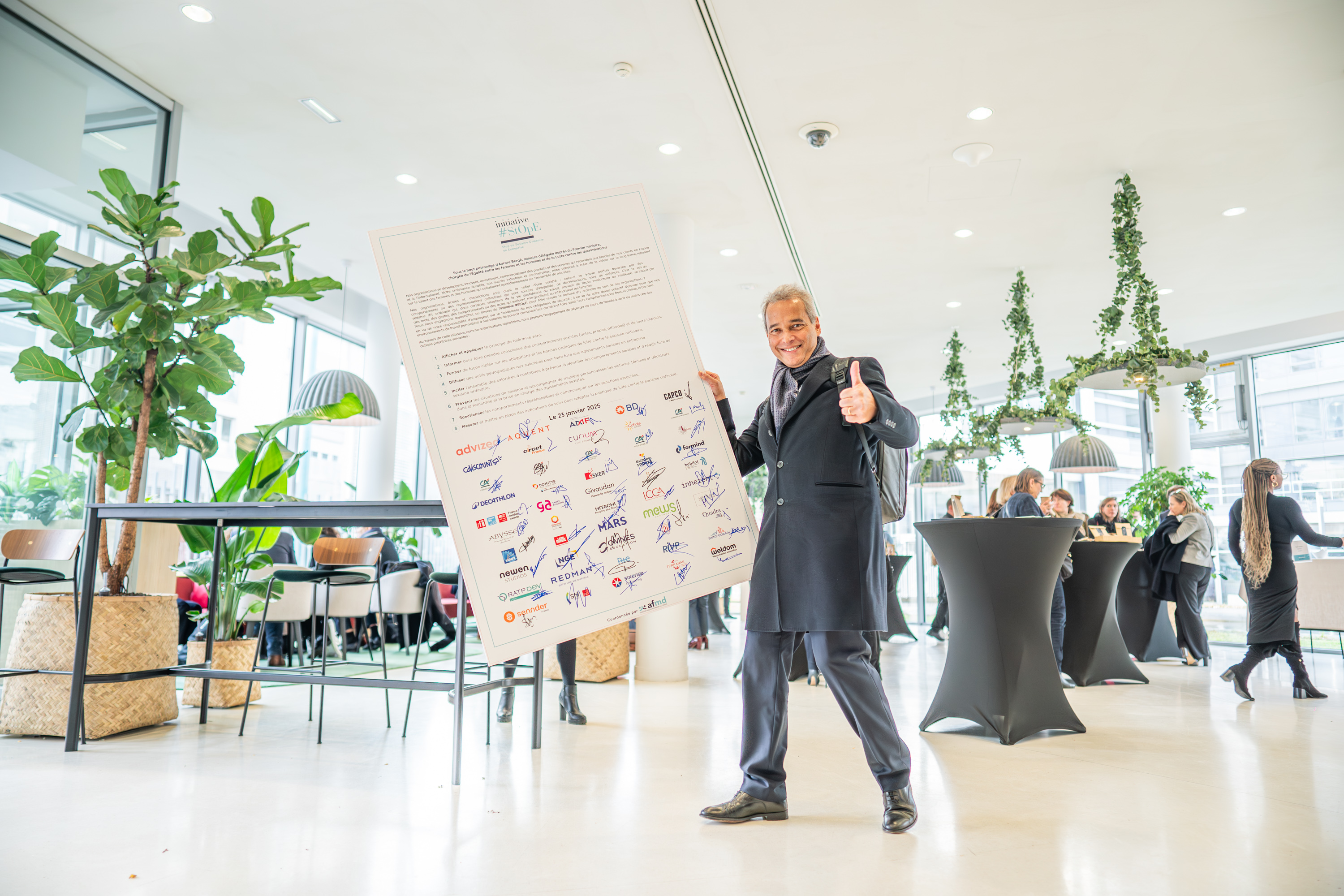 Photo d'un signataire portant le panneau de signature des huit engagements