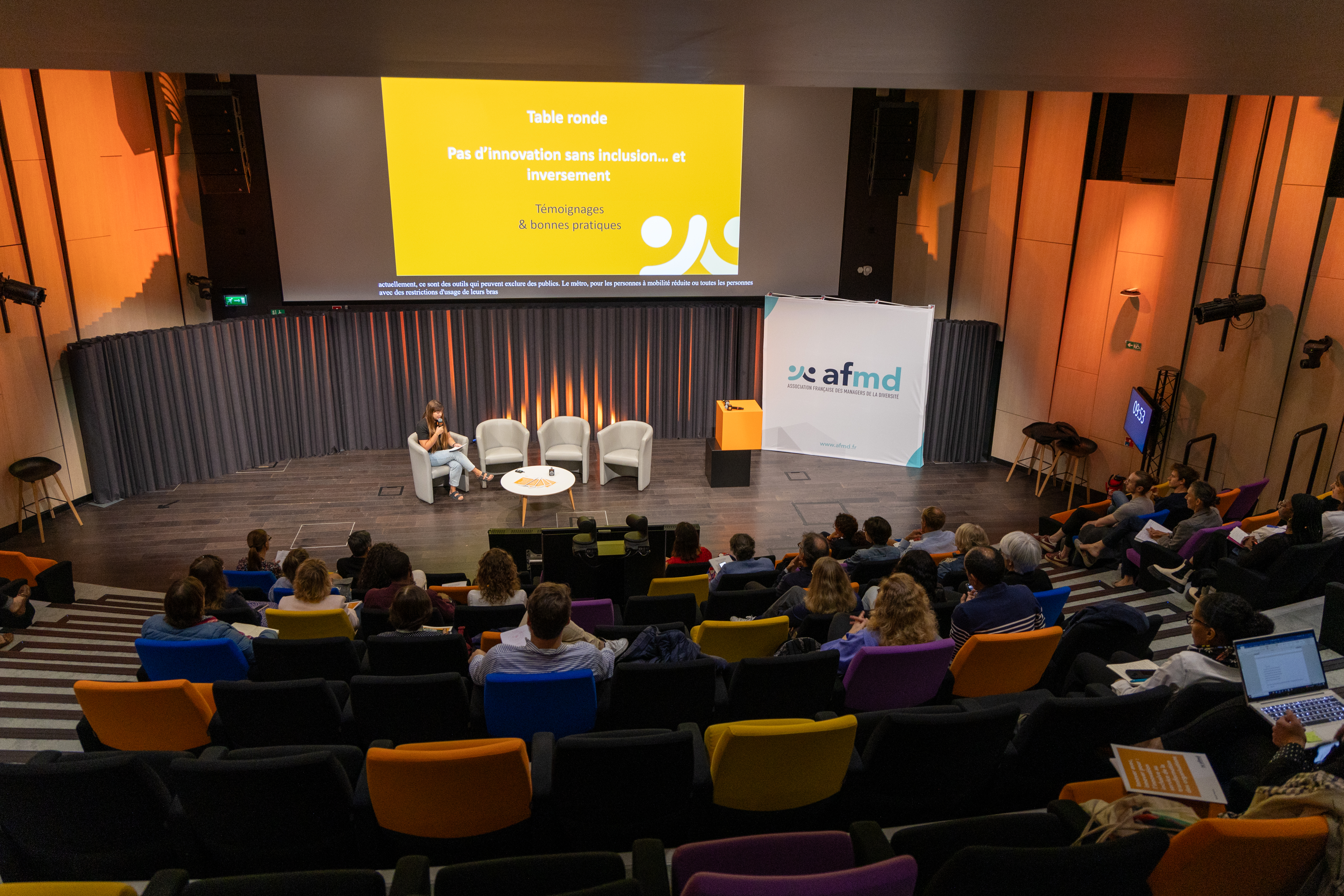 Vue en plongée de l'auditorium d'Orange, avec des participants dans les gradins